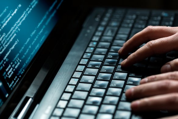 Eine Person tippt an einem Laptop | TÜVIT