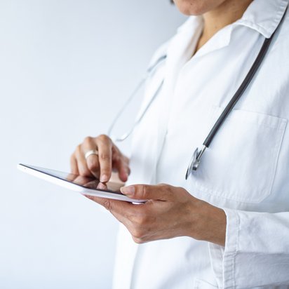 Medizinisches Fachpersonal trägt digital etwas an einem Tablet ein.