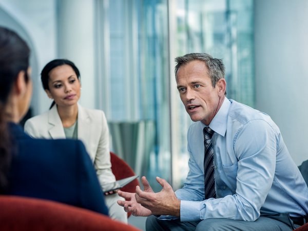 Gesprächssituation zwischen drei Personen im Büro