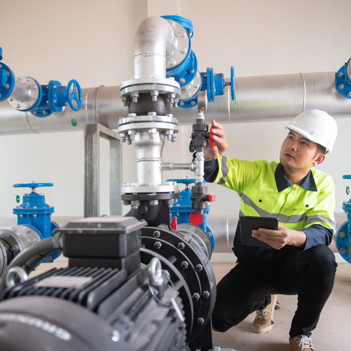 Ein Mann prüft eine Maschine zur Wasseraufbereitung | TÜVIT