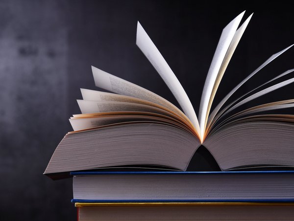 An open book on a table. | TÜVIT