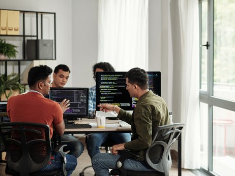 Mehrere Personen arbeiten mit Code.