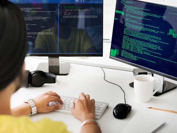 Person at two computer screens