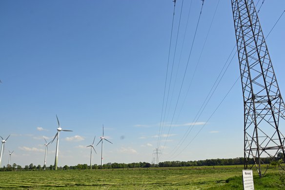 Strommast und Windräder bei gutem Wetter. | TÜVIT
