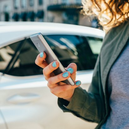 Eine Frau hält ein Smartphone in der Hand.