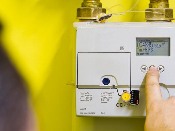 A person presses a button on an electric gas meter