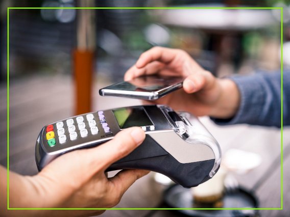 Eine Person bezahlt an einem mobilen EC-Gerät via NFC/Smartphone