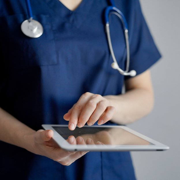 Medizinisches Fachpersonal arbeitet mit einem Tablet. | TÜVIT