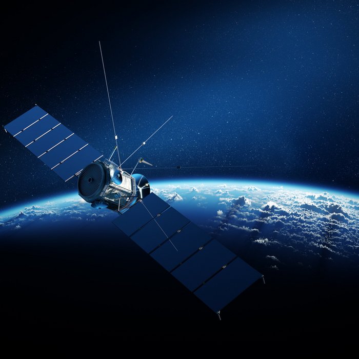 Blick auf einen Satelliten im Weltraum mit der Erde im Hintergrund | TÜVIT