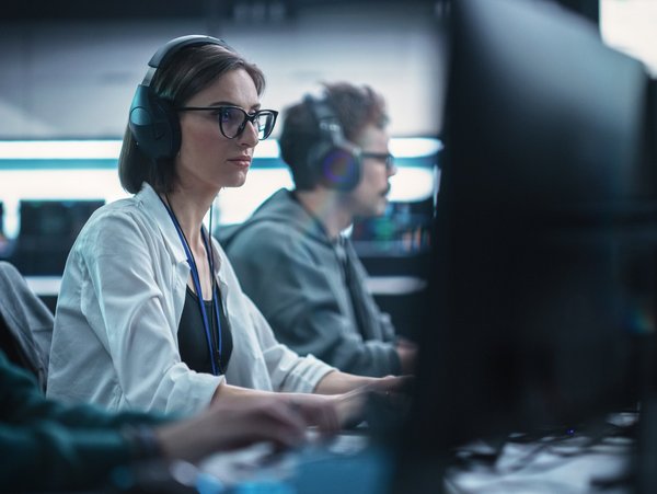 Eine Frau arbeitet an einem Schreibtisch mit PC.