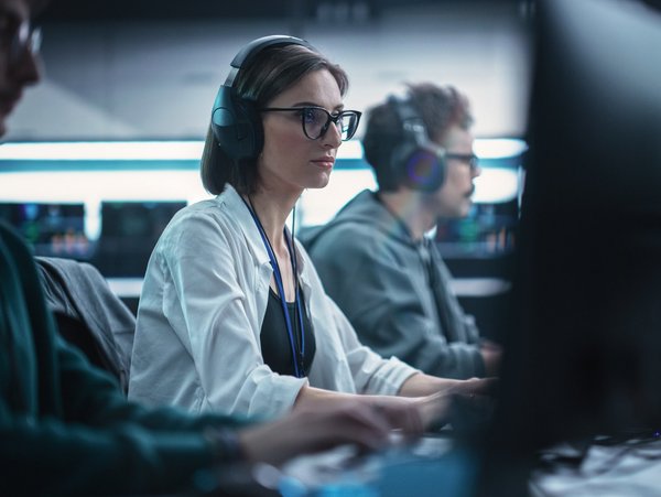 Eine Frau arbeitet an einem Schreibtisch mit PC.