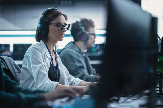 Eine Frau arbeitet an einem Schreibtisch mit PC.