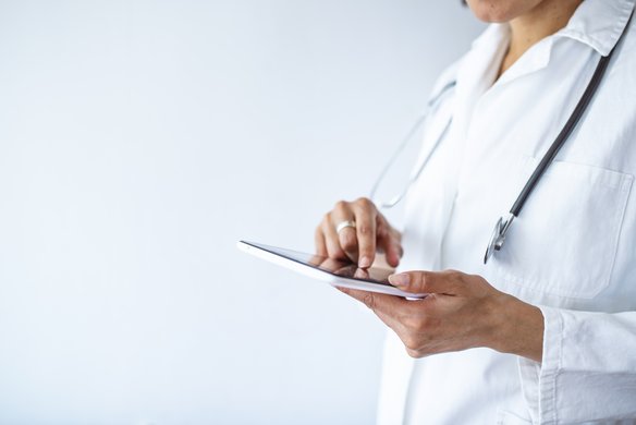 Medizinisches Fachpersonal trägt digital etwas an einem Tablet ein. | TÜVIT