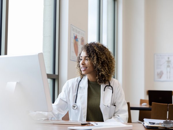 A doctor works on a computer.