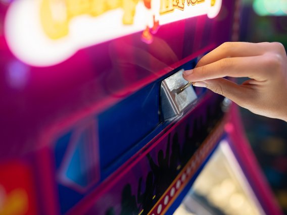 geldspielautomat Nahaufnahme der Hand einer Person, die an einem Geldspielautomaten spielt.