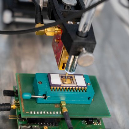 Seitenkanalmessung eines Infineon Smartcard Chips mithilfe elektromagnetischer Abstrahlung (EMA). Der Tastkopf der Langer ICR Messsonde ist exakt über der Oberfläche des Chips mit einer Mikroskopkamera positioniert.