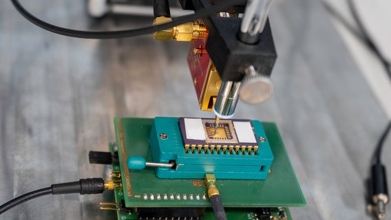 hardware-labor-seitenkanalmessung-mikroskopkamera-messsonde Seitenkanalmessung eines Infineon Smartcard Chips mithilfe elektromagnetischer Abstrahlung (EMA). Der Tastkopf der Langer ICR Messsonde ist exakt über der Oberfläche des Chips mit einer Mikroskopkamera positioniert.