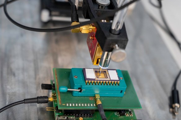 Seitenkanalmessung eines Infineon Smartcard Chips mithilfe elektromagnetischer Abstrahlung (EMA). Der Tastkopf der Langer ICR Messsonde ist exakt über der Oberfläche des Chips mit einer Mikroskopkamera positioniert.