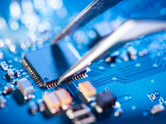 hardware-pinzette-blau Eine Pinzette entnimmt Hardware von einem PCB-Board.
