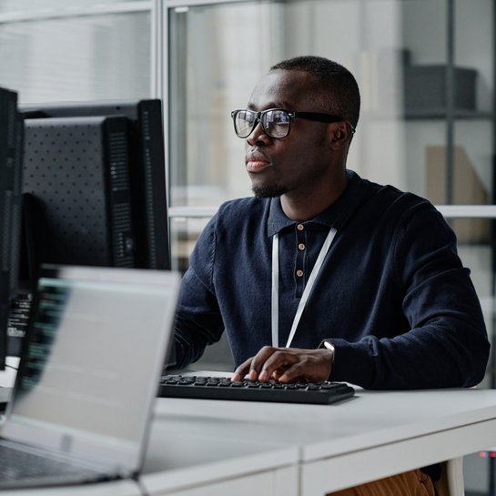 One person working at a desk on a PC
