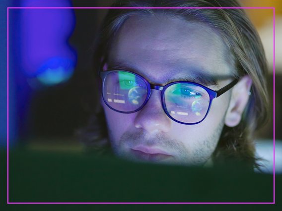 brille-bildschirm Bildschirminhalte spiegeln sich in der Brille eines Mitarbeitenden.