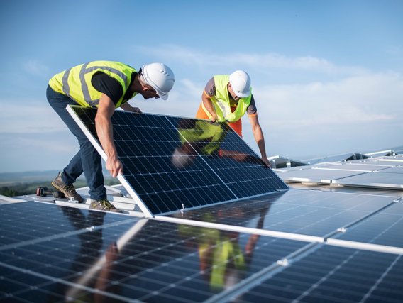 Solarenergie-Solarpanel Zwei Männer bringen Solarpanele an
