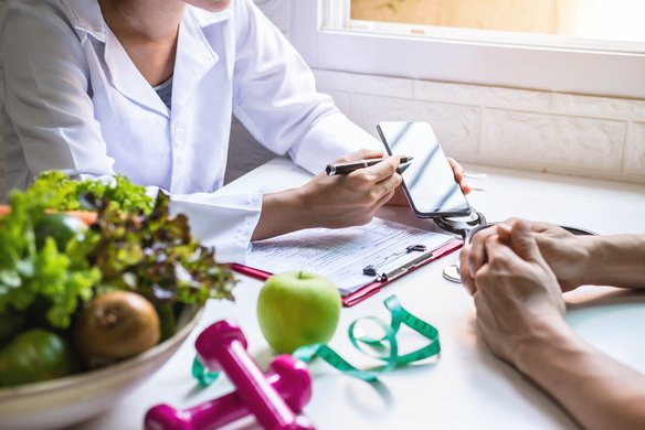 Medizinisches Fachpersonale zeigt einem Patienten eine Gesundheits-App. | TÜVIT