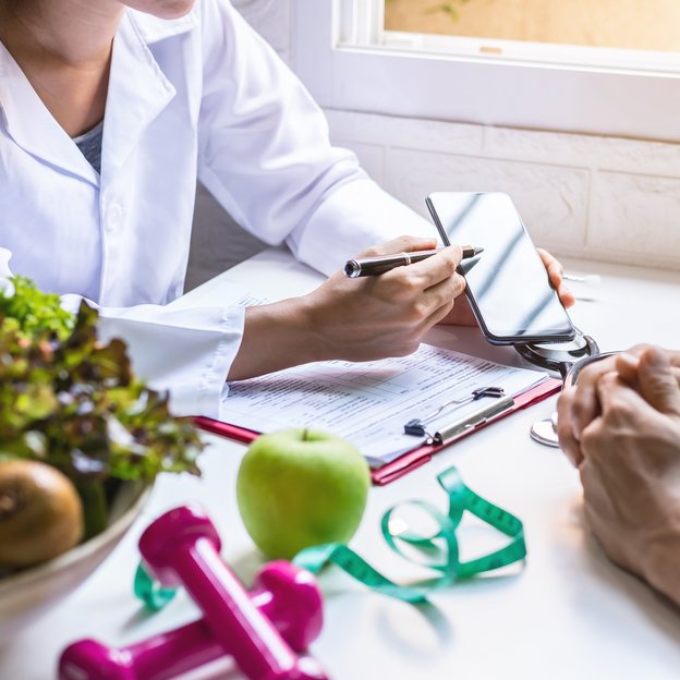 Medizinisches Fachpersonale zeigt einem Patienten eine Gesundheits-App. | TÜVIT