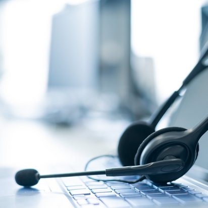 Headset-Laptop Ein Headset lehnt am Bildschirm eines Laptops.