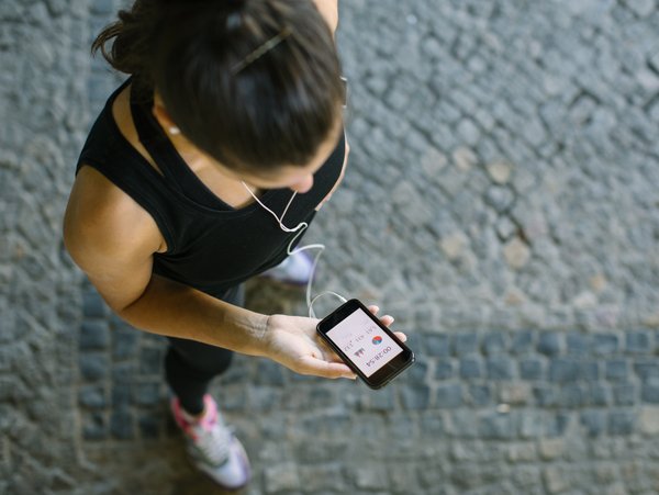 A woman checks her health app while exercising.
