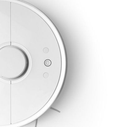 Weißer Saugroboter fährt von links in das Bild hinein