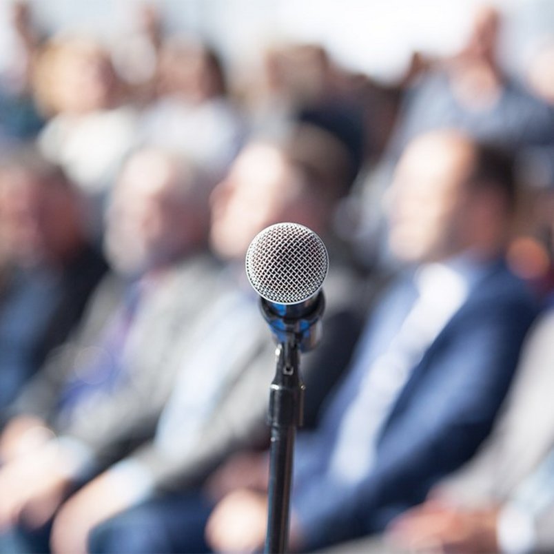 Mikrofon vor Veranstaltungsteilnehmenden