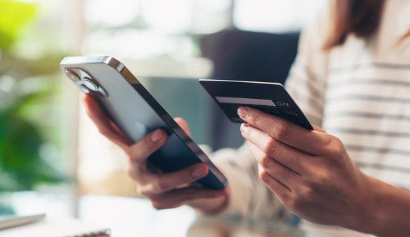 Frau gibt Kontodaten am Smartphone ein