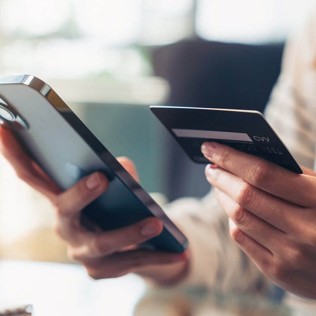 Frau gibt Kontodaten am Smartphone ein