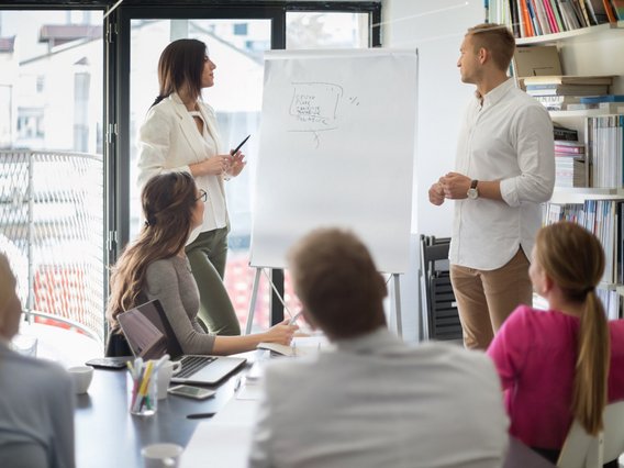 Two people present the results of their work to their team.