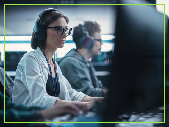 headset-großraumbüro Mitarbeitende im IT-Umfeld arbeiten mit Headset in einem Großraumbüro.